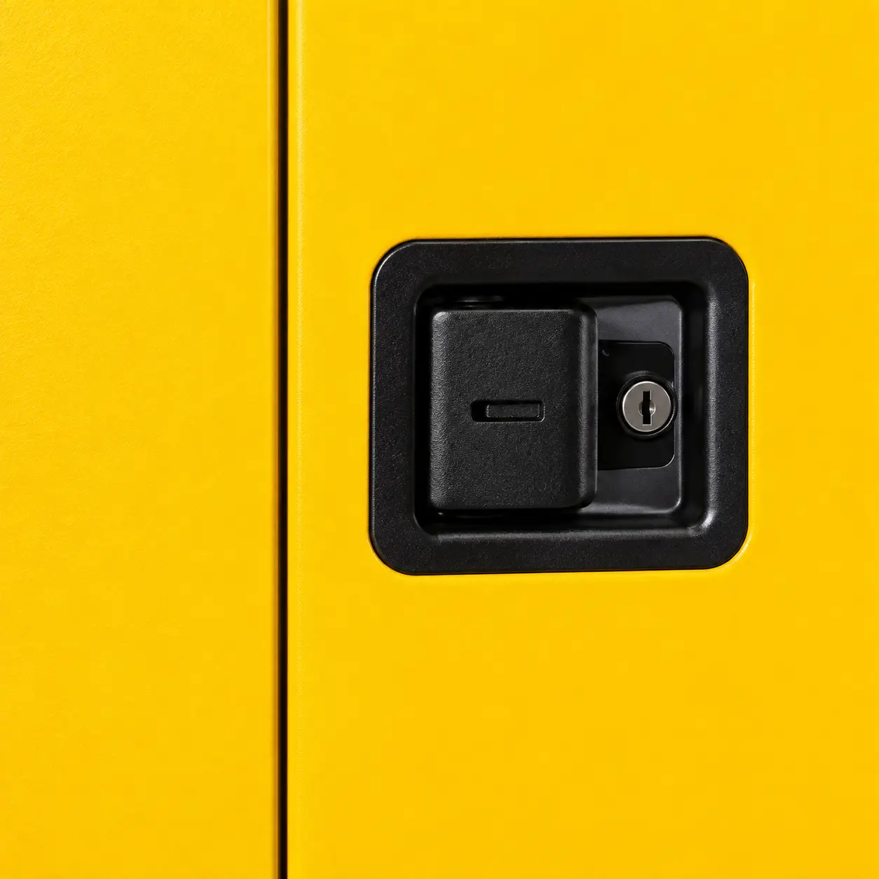 Editorial close-up of a yellow cabinet door and black recessed handle